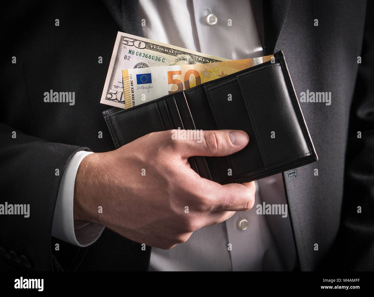 Dollars and euros in wallet. Exchange rate, world economy and financial concept. Business man in a suit with paper money, banknote and bill in hand. Stock Photo