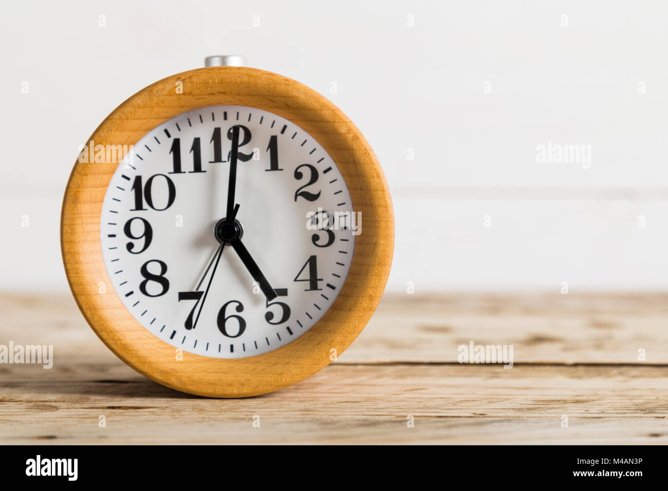 Wooden clock on a bedside table Stock Photo