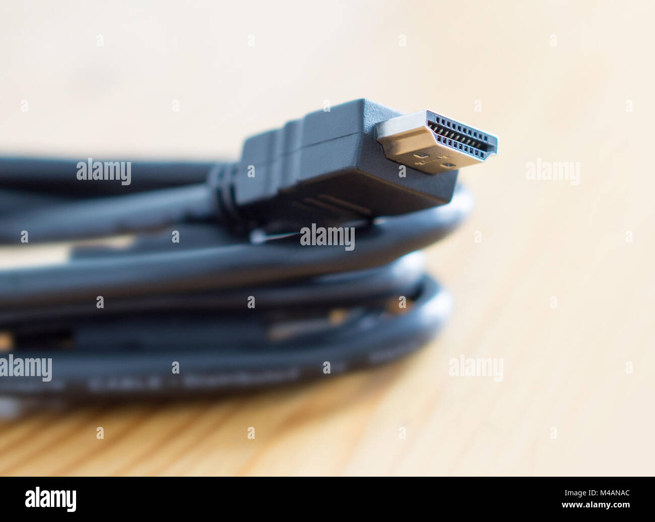 HDMI cable on wooden table at home. Copy space. Stock Photo