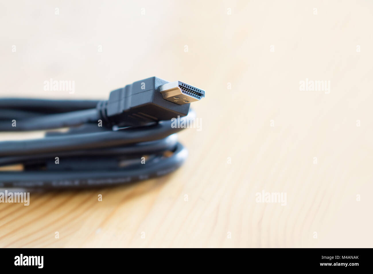 HDMI cable on wooden table at home. Copy space. Stock Photo