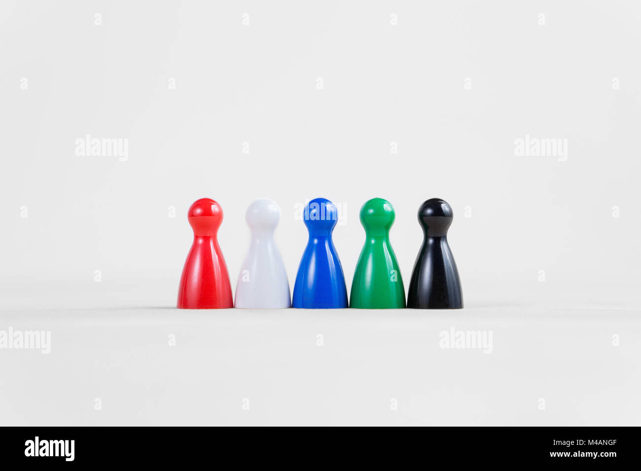 Colorful board game pawns in a row with copy space. Suitable for business concept such as teamwork, recruiting, cooperation and working together. Stock Photo