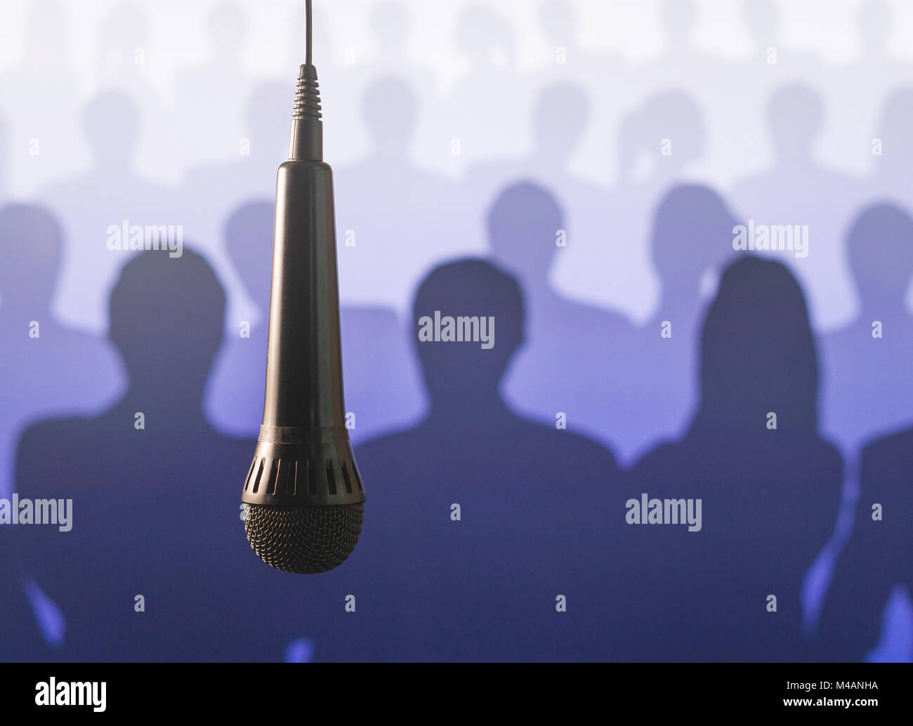 Public speaking and giving speech. Singing to mic in karaoke or talent show background. Close up of microphone hanging from ceiling from wire. Stock Photo