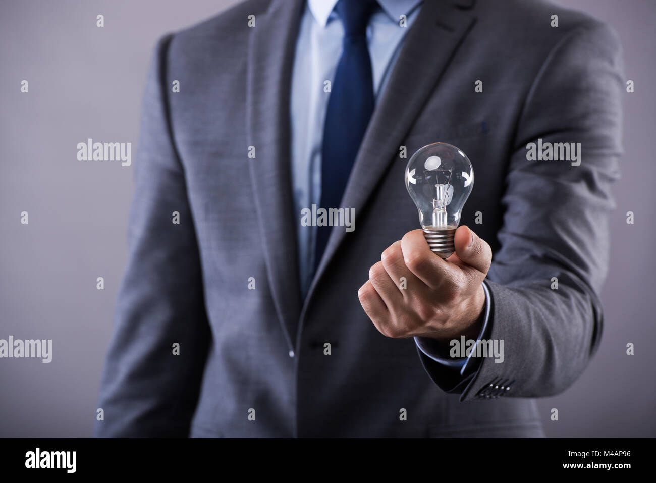 Businessman holding light bulb in creativity concept Stock Photo - Alamy