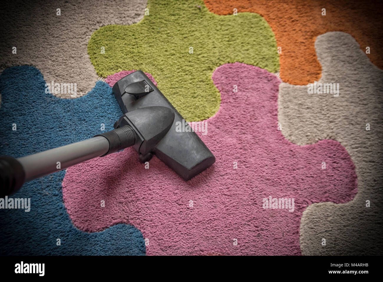 A vacuum cleaner on a colorful carpet Stock Photo