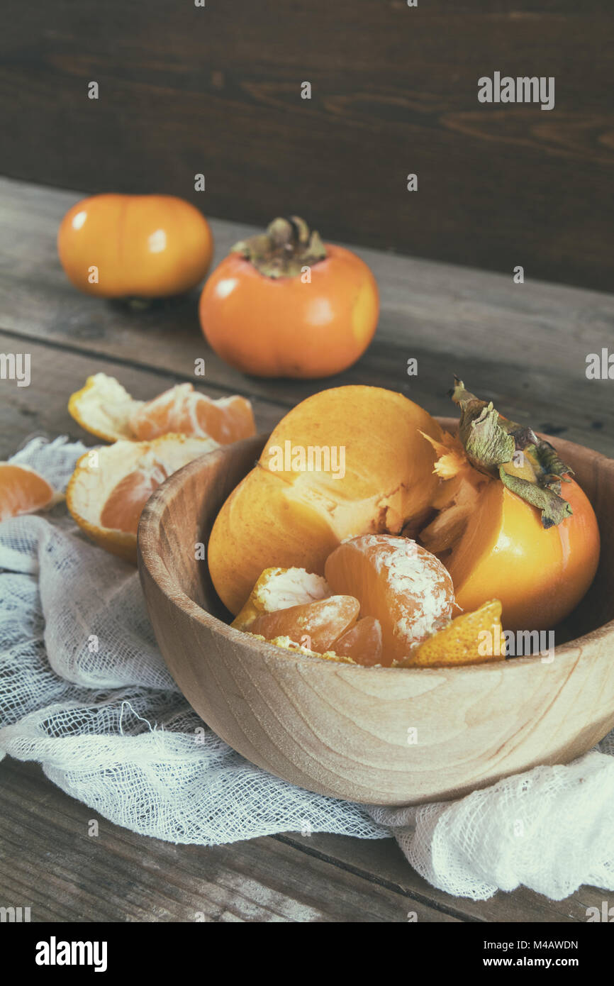 Fresh persimmons and tangerines fruits in bowl Stock Photo Alamy