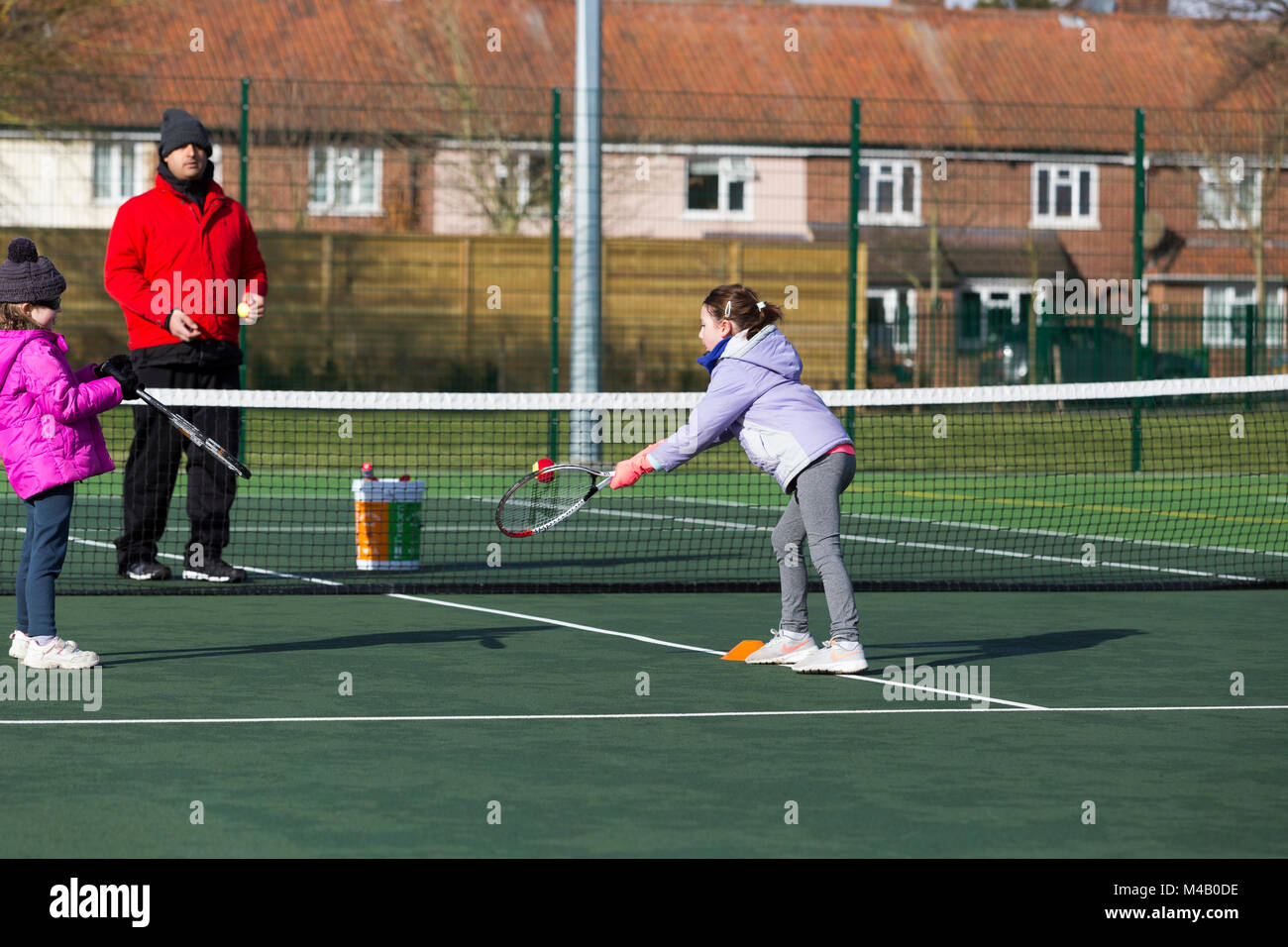 Children's tennis coaching session / lesson taking place on a fullsize