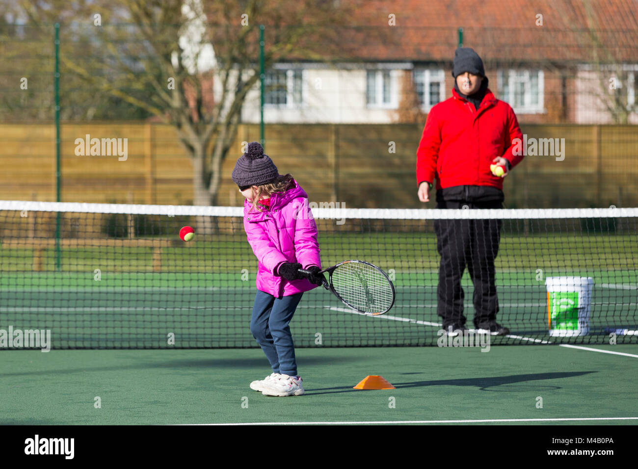 Children's tennis coaching session / lesson taking place on a fullsize