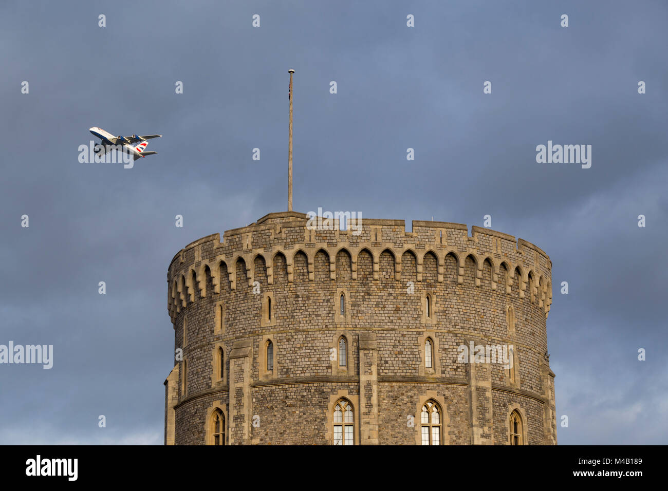 BA A380 Aircraft / aeroplane / air plane / flight from Heathrow airport passing over the round tower of Windsor Castle while climbing after take off. Stock Photo
