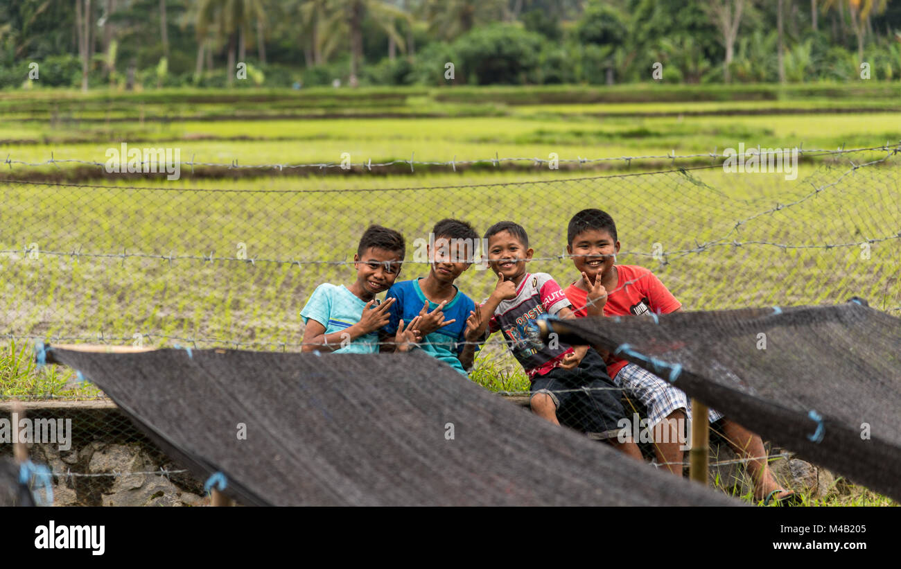 Four balinese children play in the rice fields on Bali,Indonesia Stock Photo