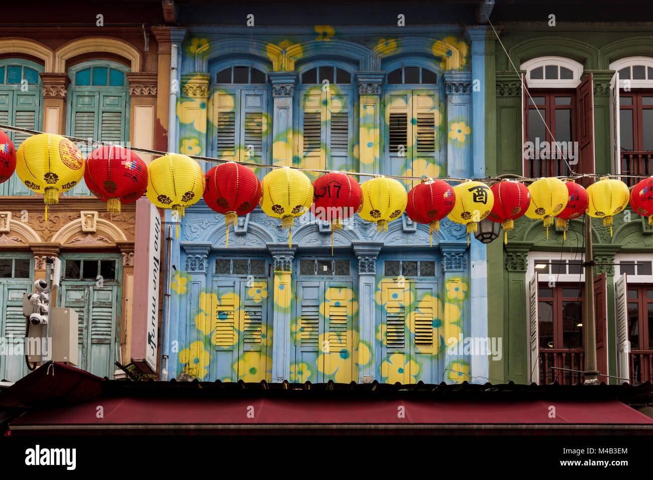 Singapore,Chinatown,street decoration,lampions in yellow and red over the street in front of coloured house facade Stock Photo