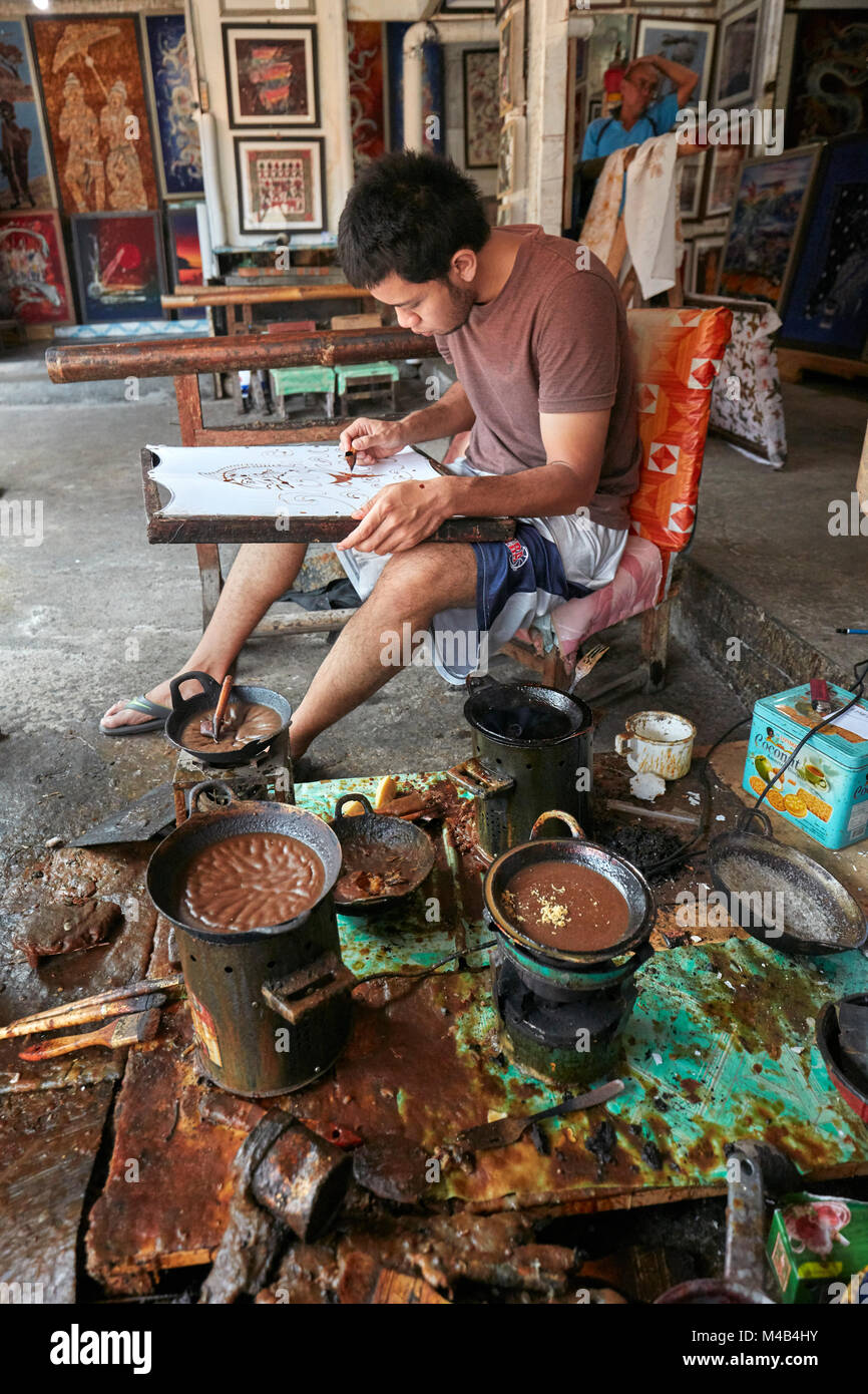 A batik maker works in his workshop at Batik Seno, a gallery in ...