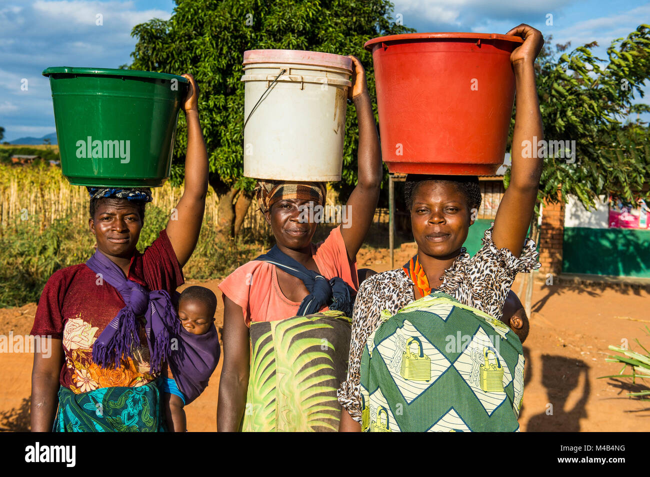 Local women carrying buckets on their head,Malawi,Africa Stock Photo