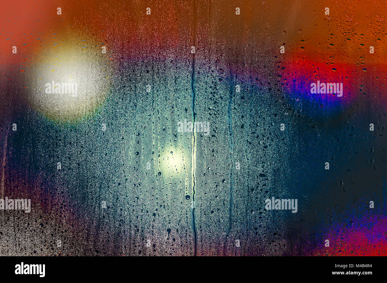 Drops and water spots on the glass on a rainy evening, multicolored spots and lights shining Stock Photo