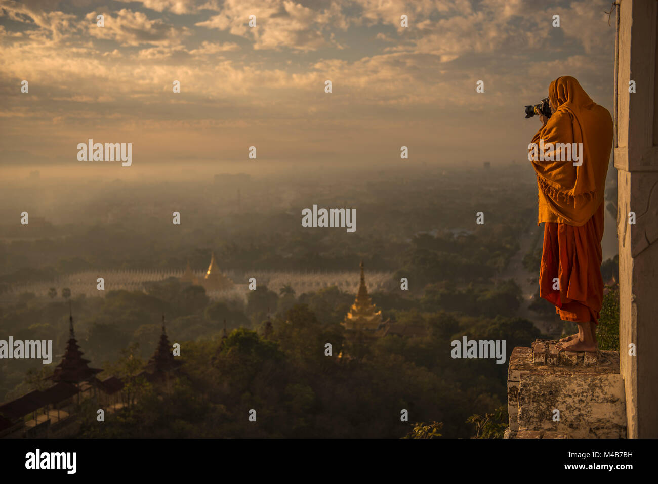 Buddhist monk taking photos of Buddhist temple landmarks in the sunrise valley of Bagan Stock Photo