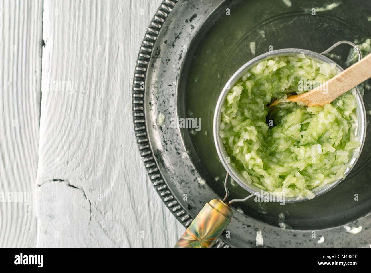 Pressing grated cucumbers in the  strainer top view Stock Photo
