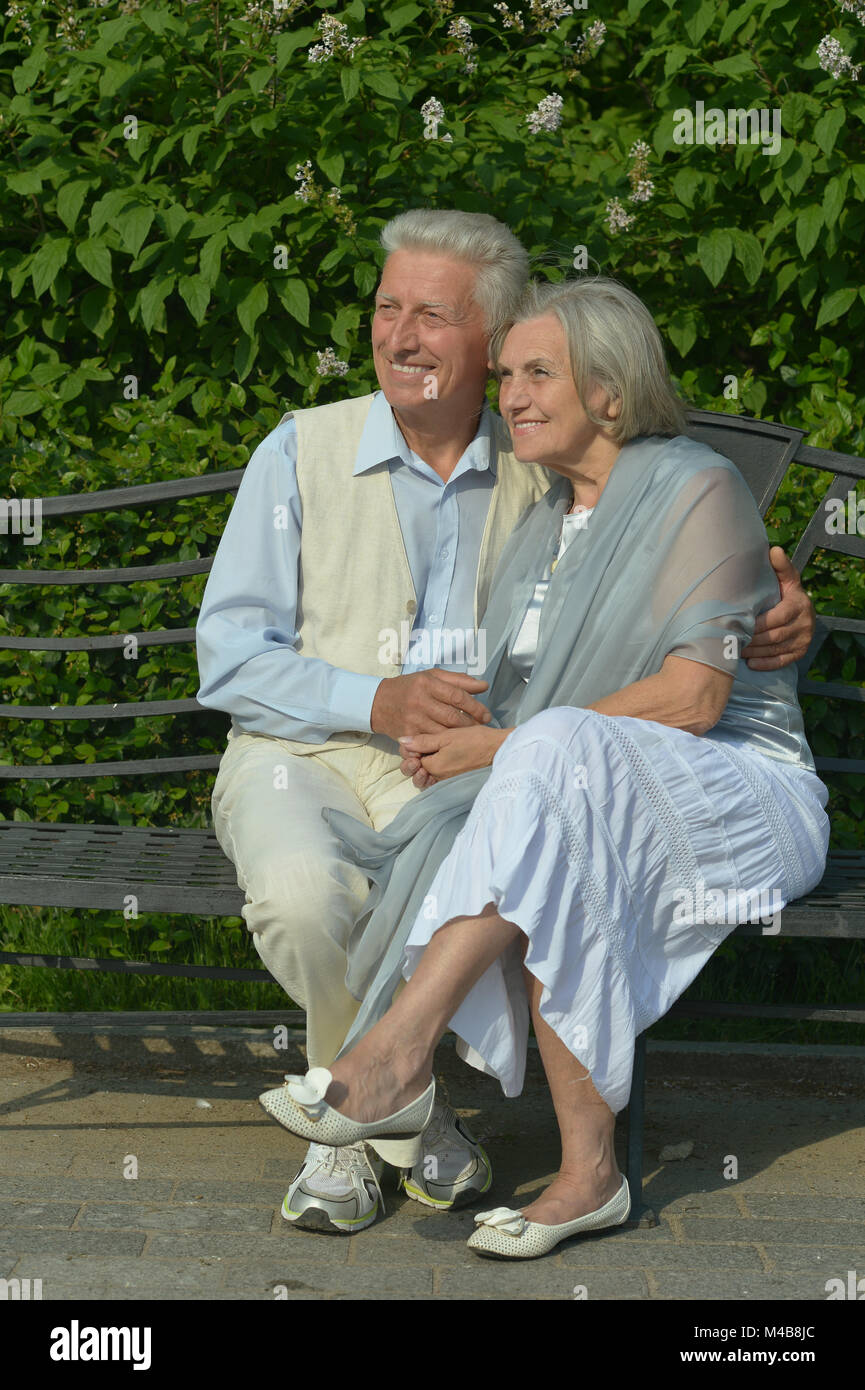 beautiful caucasian senior couple in the park sitting Stock Photo - Alamy