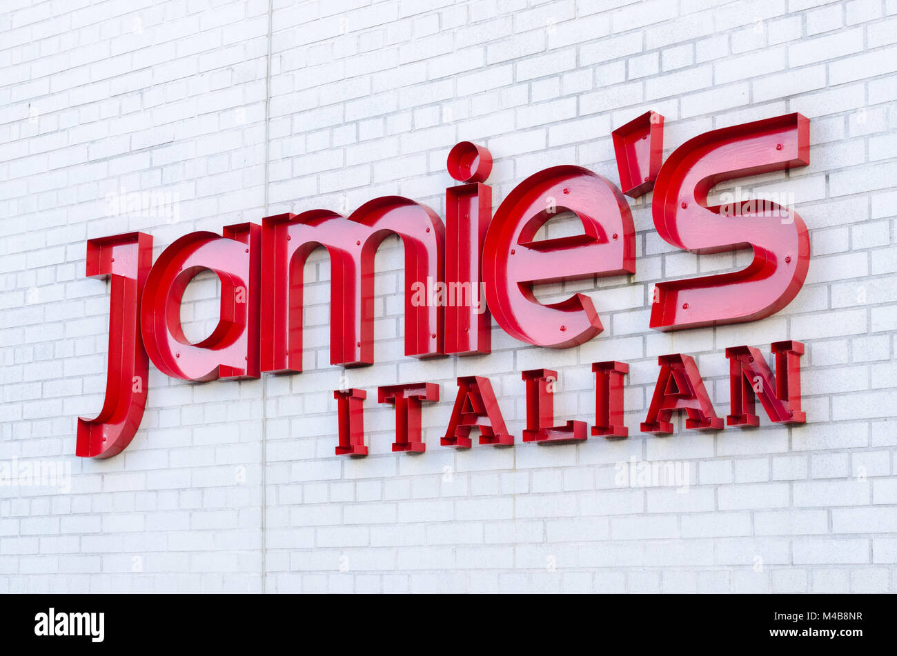 Sign for Jamie's Italian restaurant on white brick wall in the Bullring Shopping centre in Birmingham, UK Stock Photo