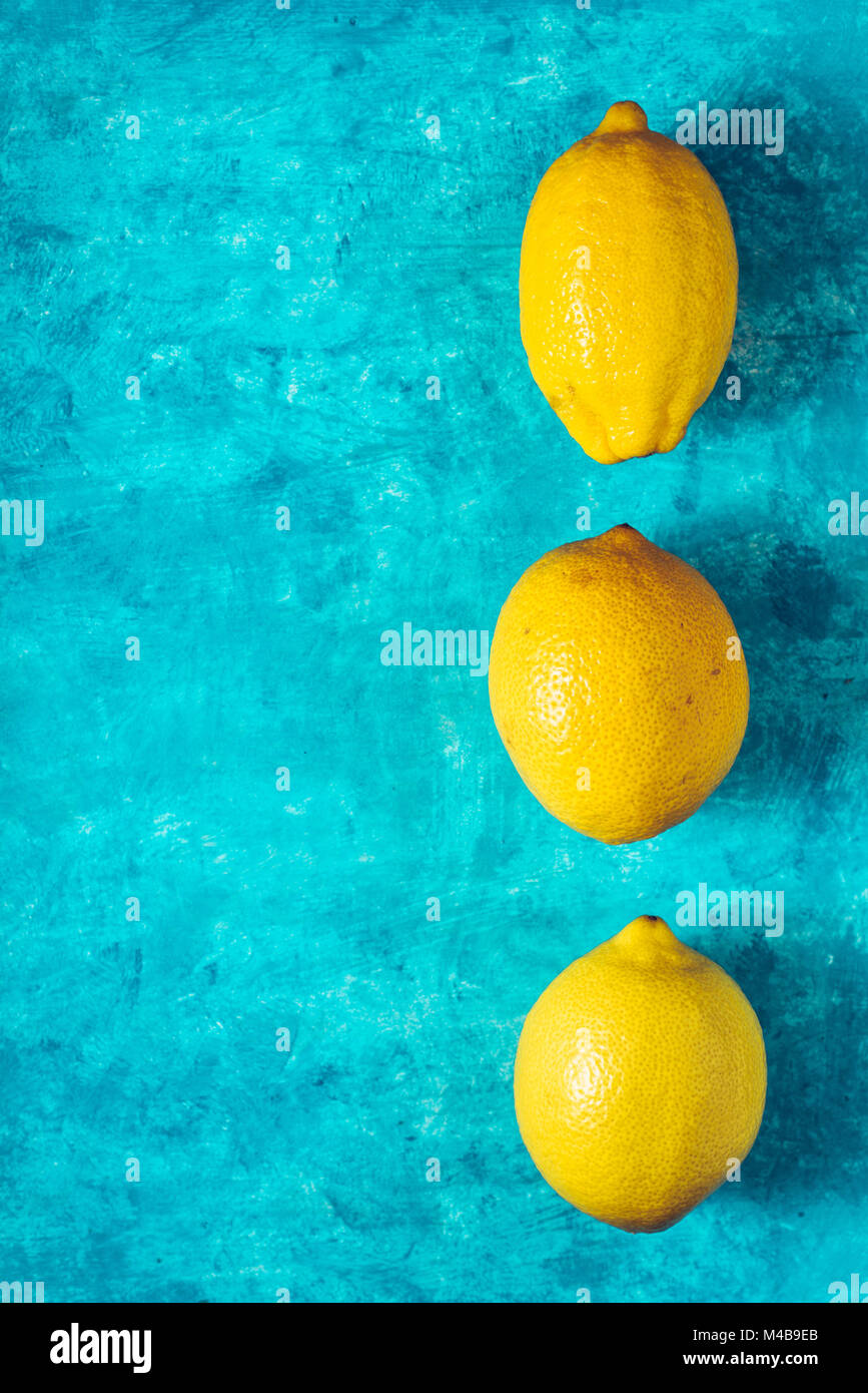 Yellow lemons on the cyan background top view Stock Photo