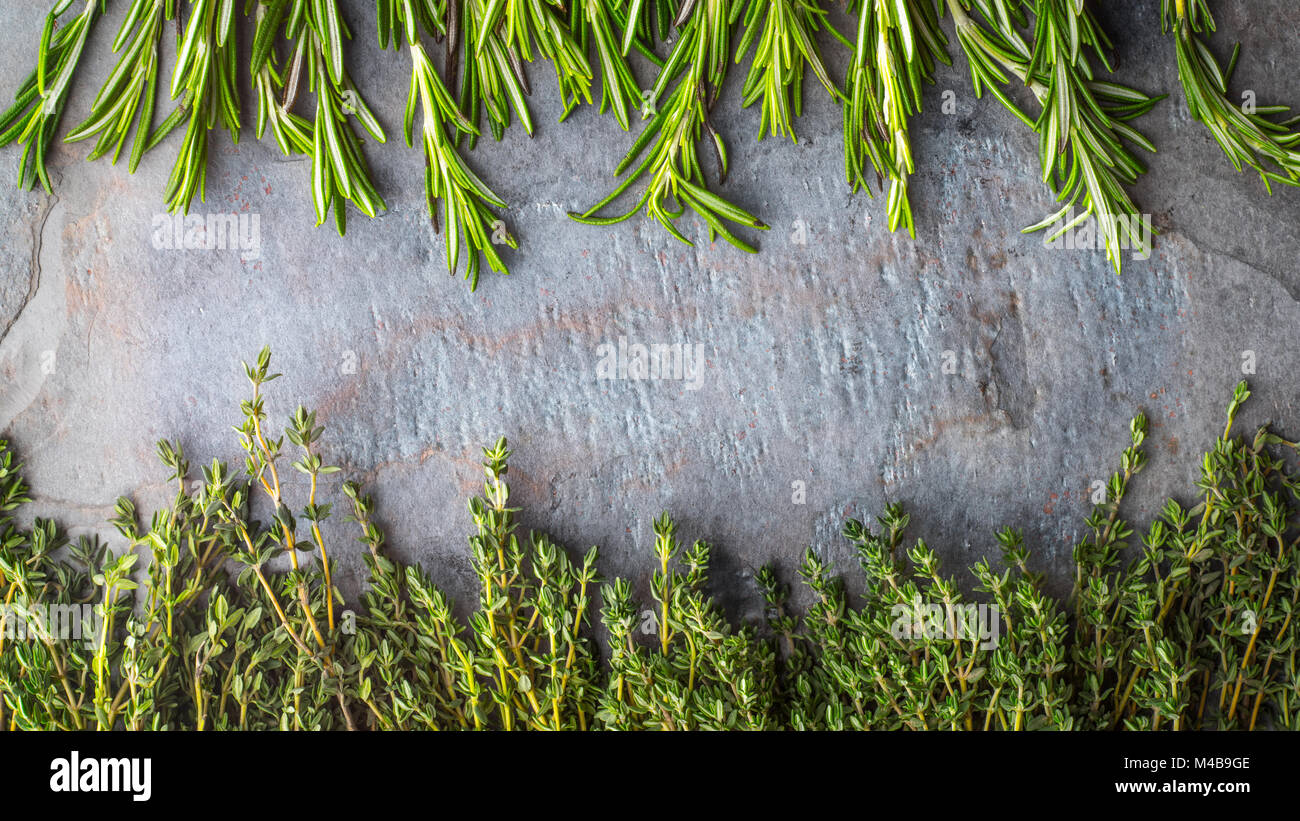 Thyme  and rosemary sprigs on the stone table Stock Photo