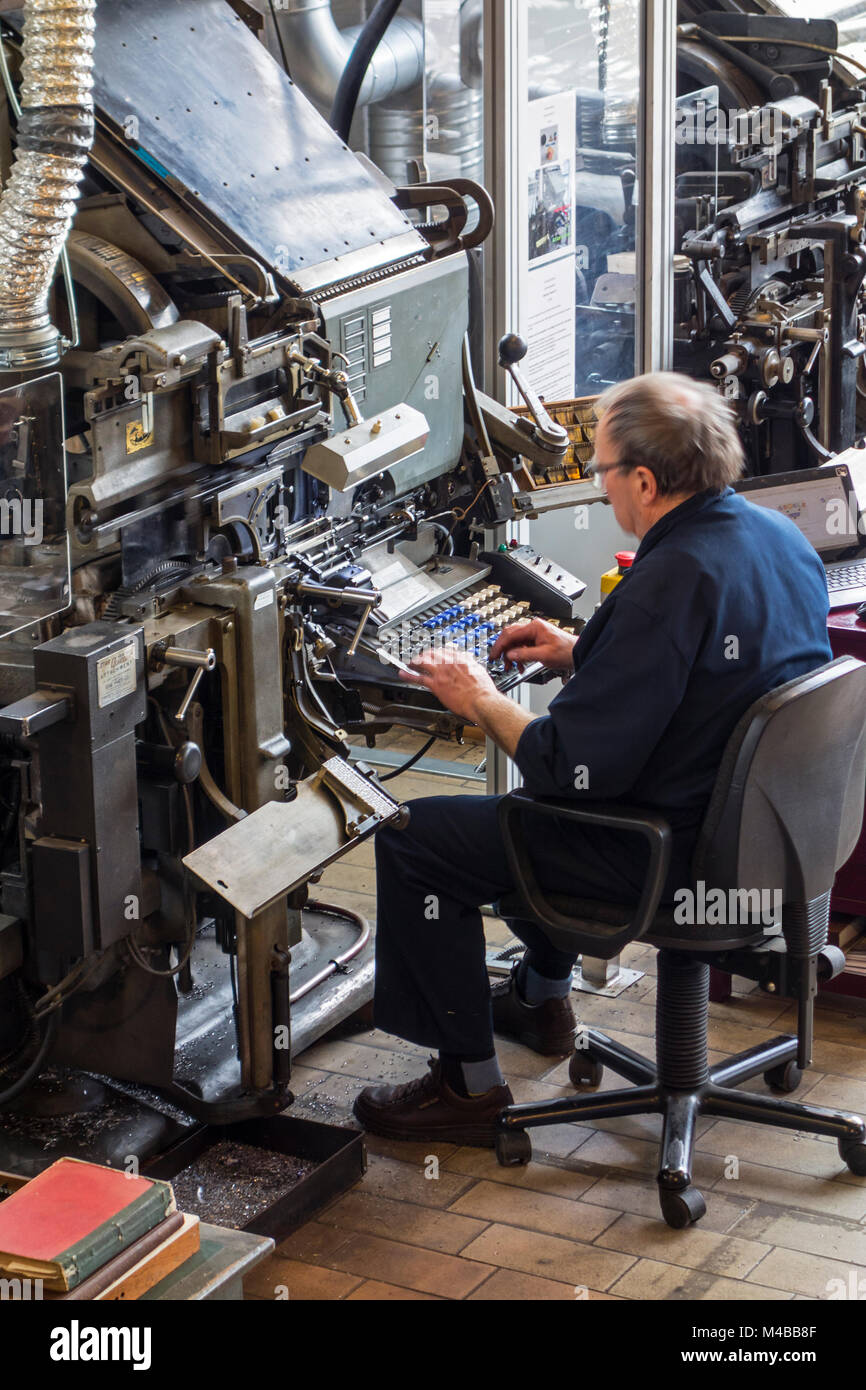 Linotype machine operator enters text on a 90-character keyboard at printing business Stock Photo