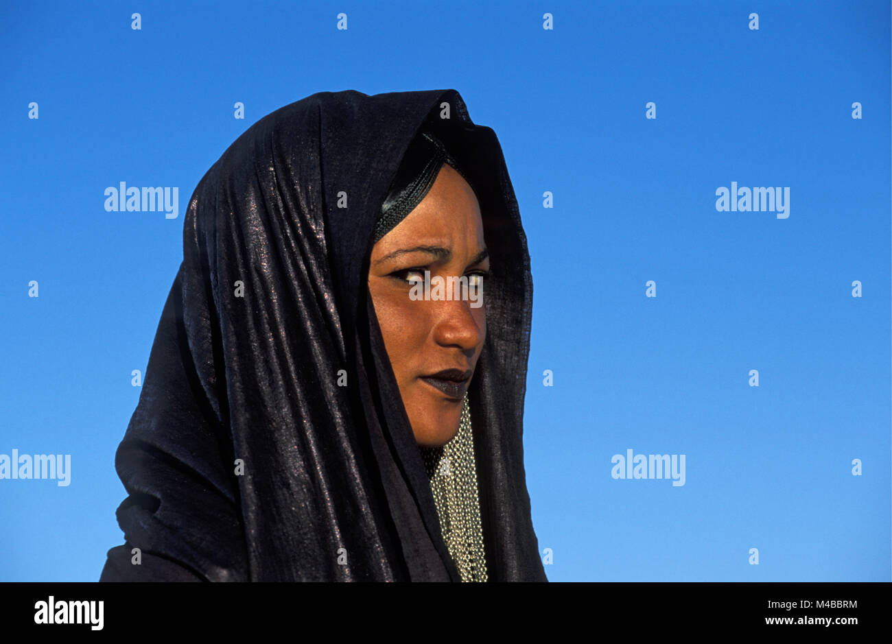 Algeria. Near Djanet. Sahara desert. Veiled woman of Tuareg tribe. Indigo blue headscarf. Portrait. Stock Photo