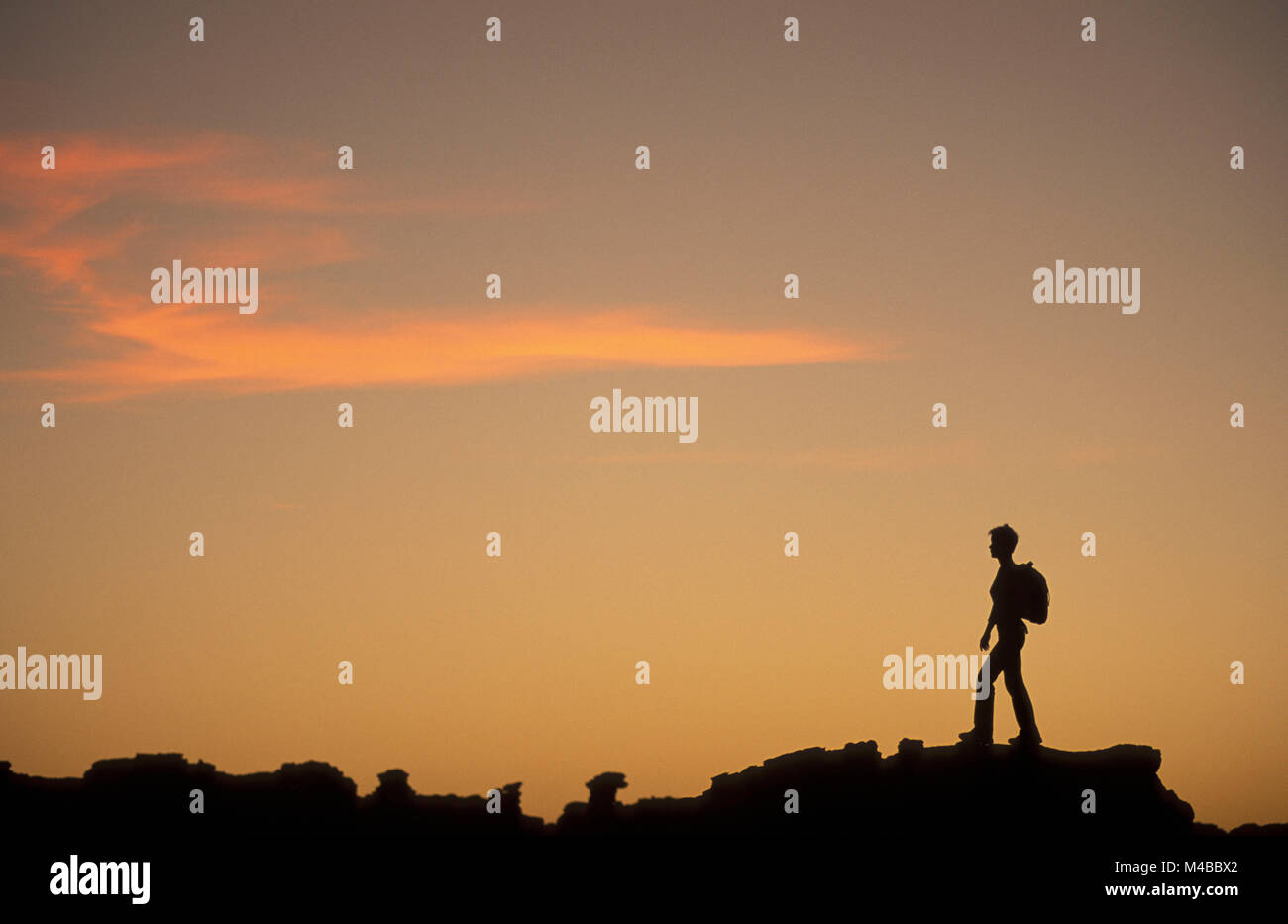 Algeria, Djanet. Sahara desert. National Park Tassili n'Ajjer.  Silhouette of woman hiking. UNESCO World Heritage site. Stock Photo