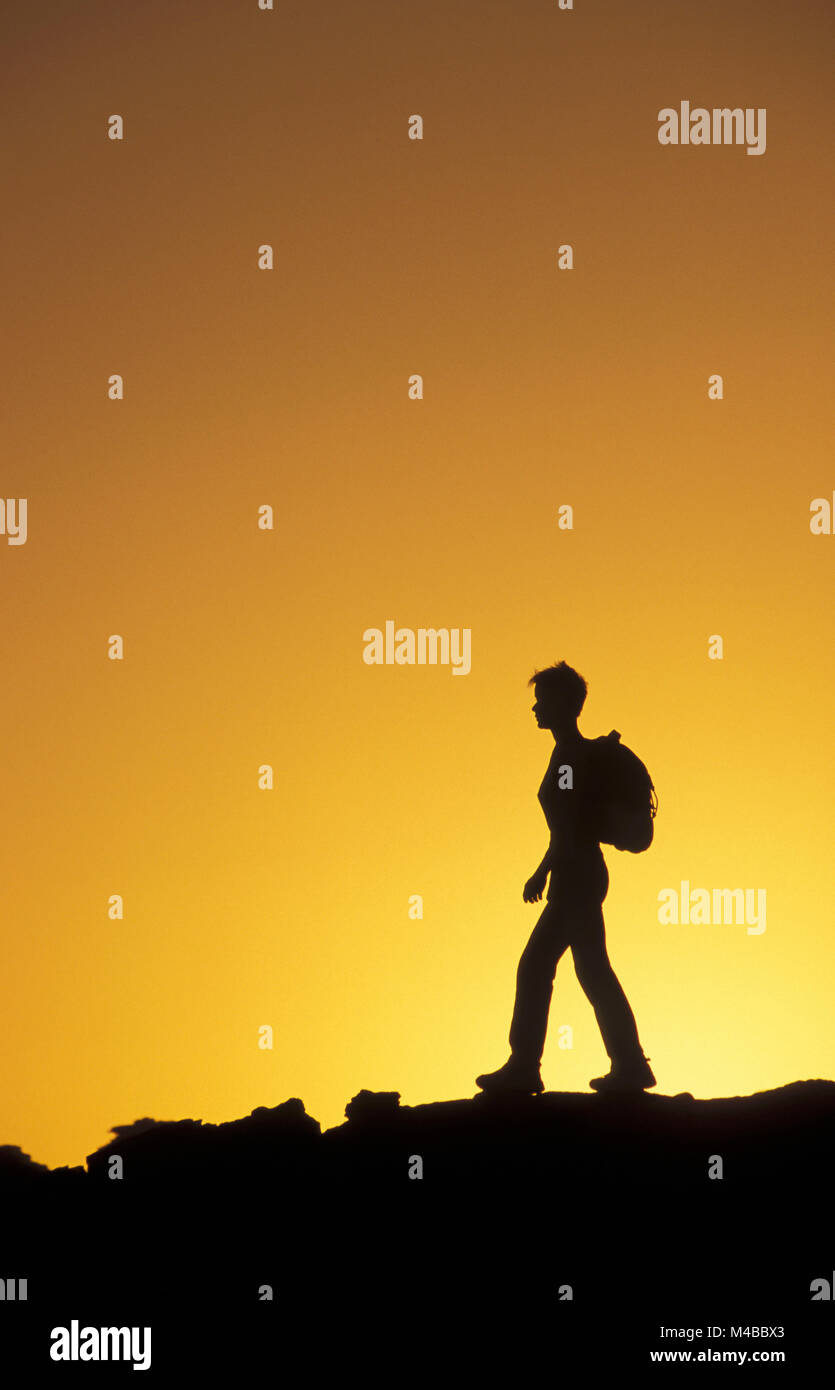 Algeria, Djanet. Sahara desert. National Park Tassili n'Ajjer.  Silhouette of woman hiking. UNESCO World Heritage site. Stock Photo