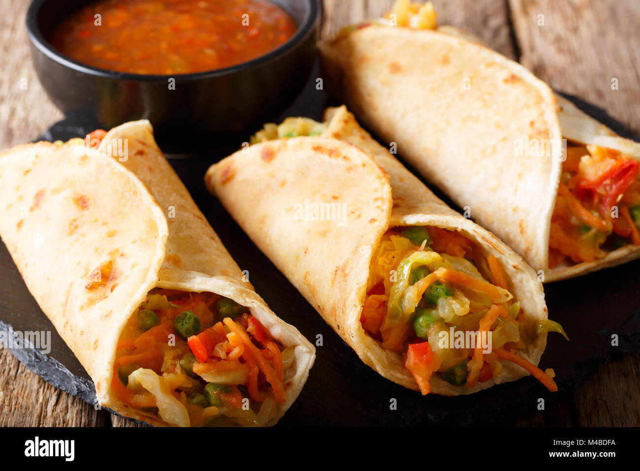 Indian street vegetarian food: Franky Roti roll stuffed with vegetables close-up on the table. horizontal Stock Photo