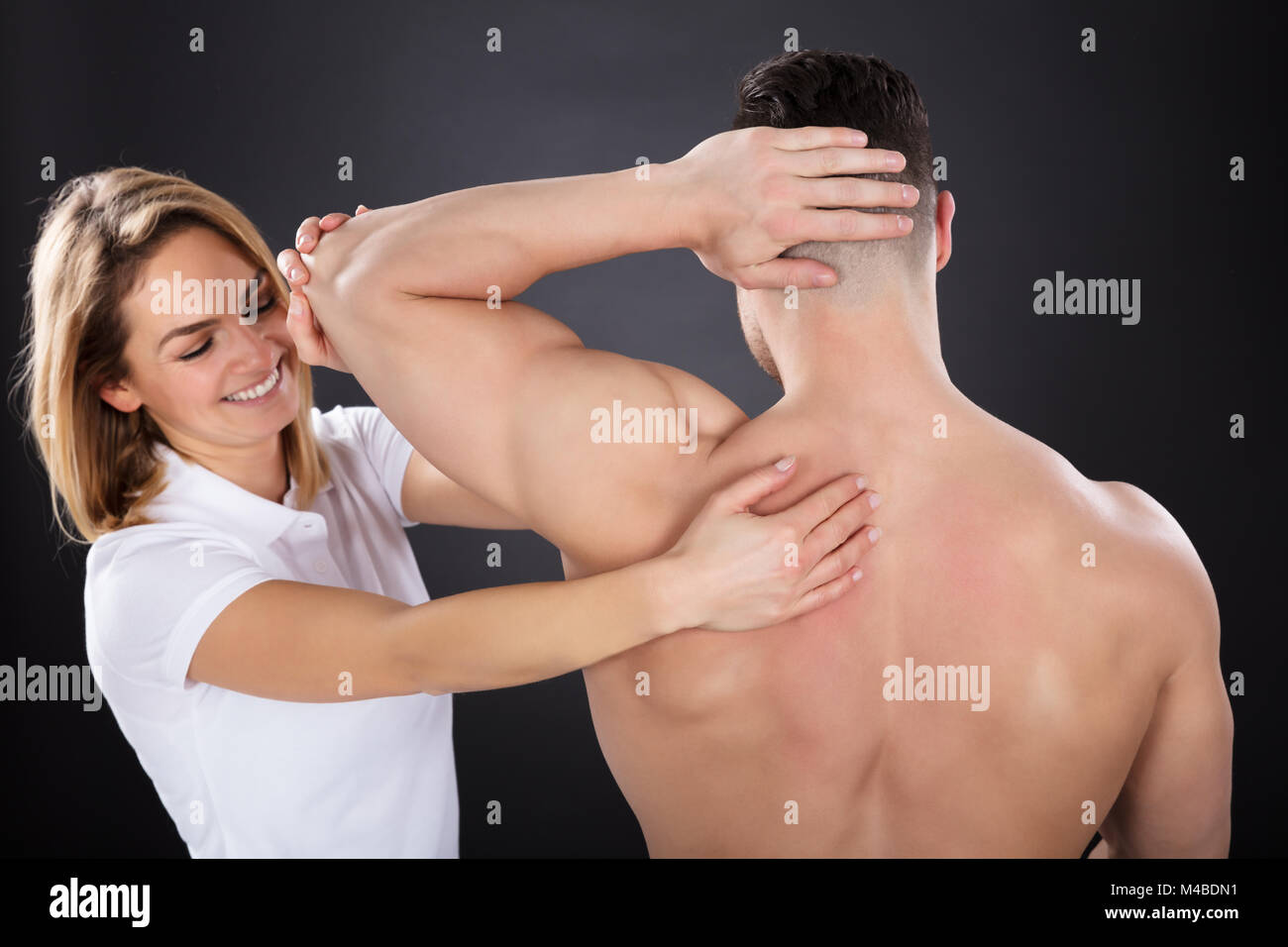 https://c8.alamy.com/comp/M4BDN1/young-smiling-female-physiotherapist-giving-a-man-shoulder-massage-M4BDN1.jpg