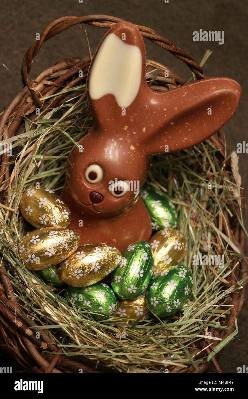 Chocolate Easter bunny in a basket Stock Photo - Alamy