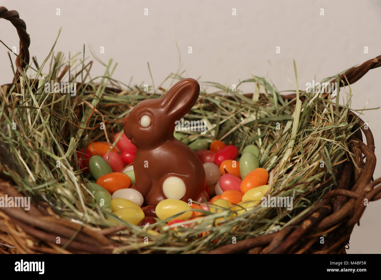 Chocolate Easter bunny in a basket Stock Photo - Alamy