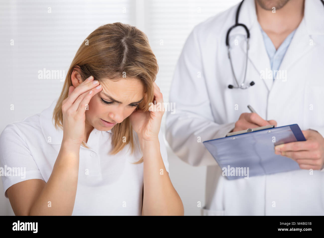 Female Patient With Headache In A Clinic Stock Photo