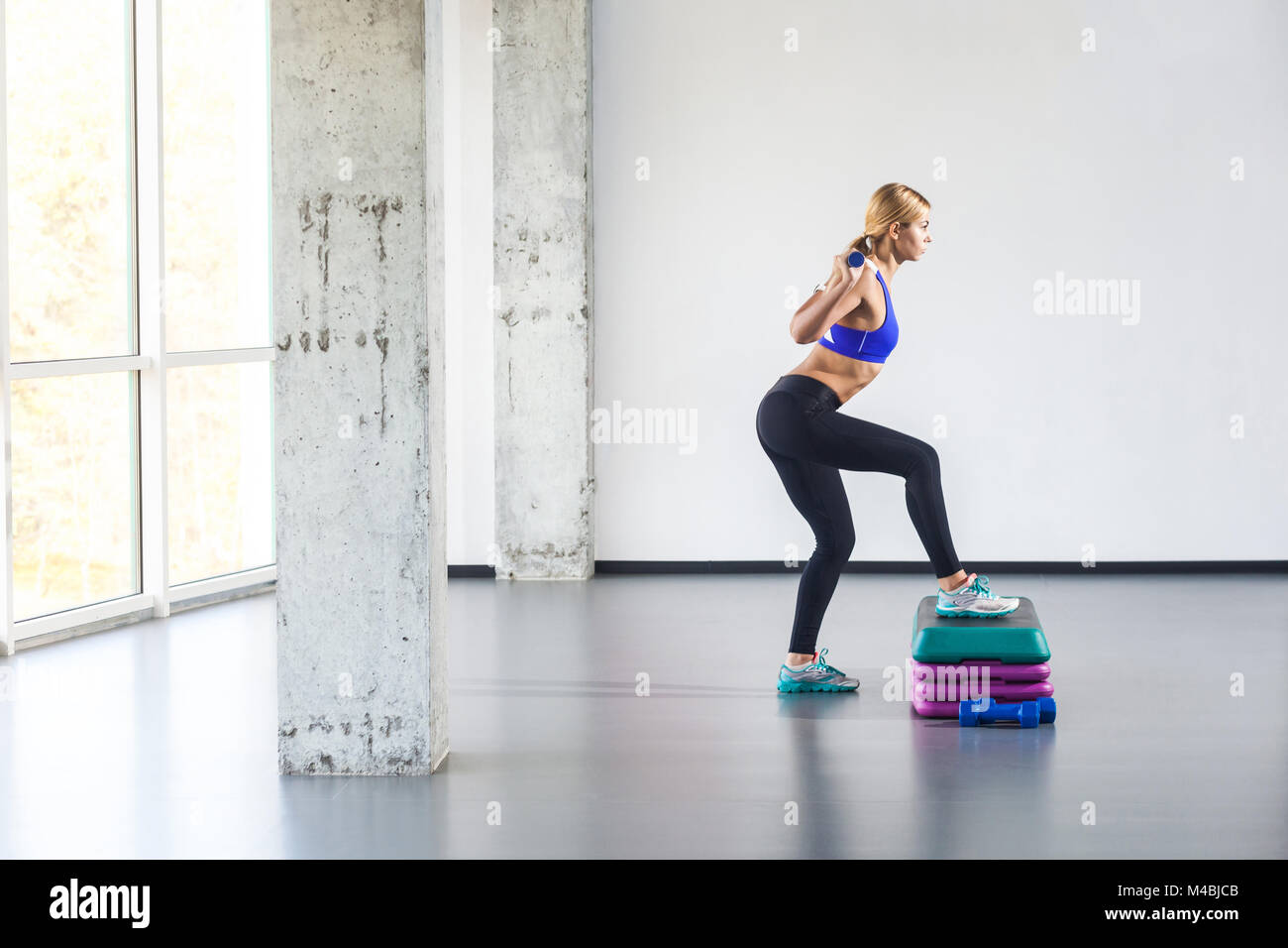 Blonde woman practice on step platform. Studio shot Stock Photo - Alamy