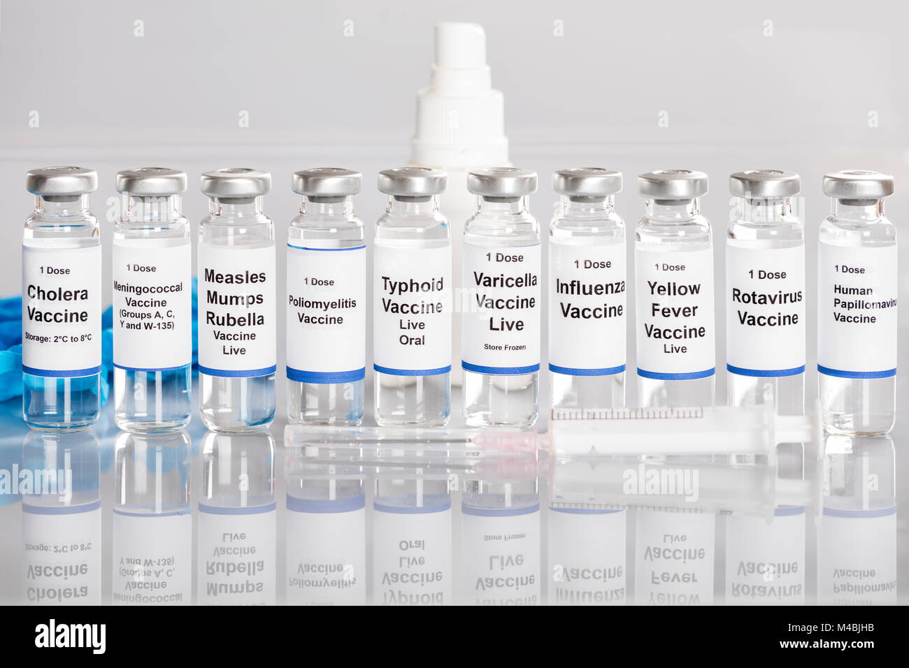 Syringe And Vaccine Bottles With Different Labels In A Row Stock Photo