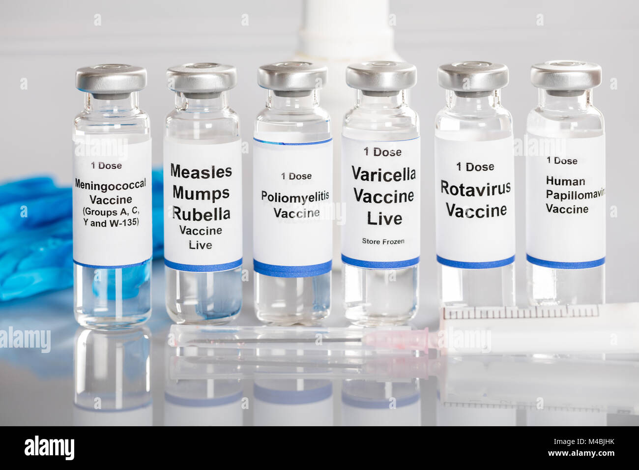 Syringe And Vaccine Bottles With Different Labels In A Row Stock Photo