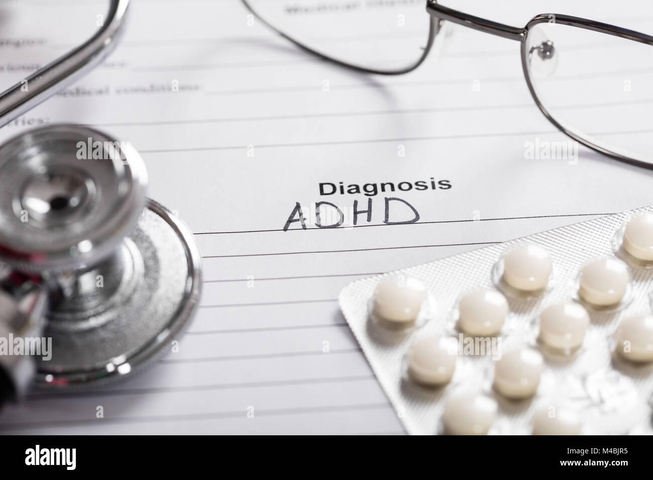Pills;Glasses And Stethoscope With Text Diagnosis ADHD On Paper Stock Photo