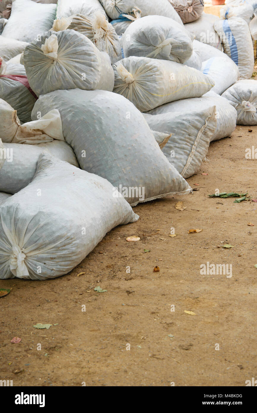 Hemp sacks full of harvest products accumulated on the ground. Agriculture, business concept Stock Photo