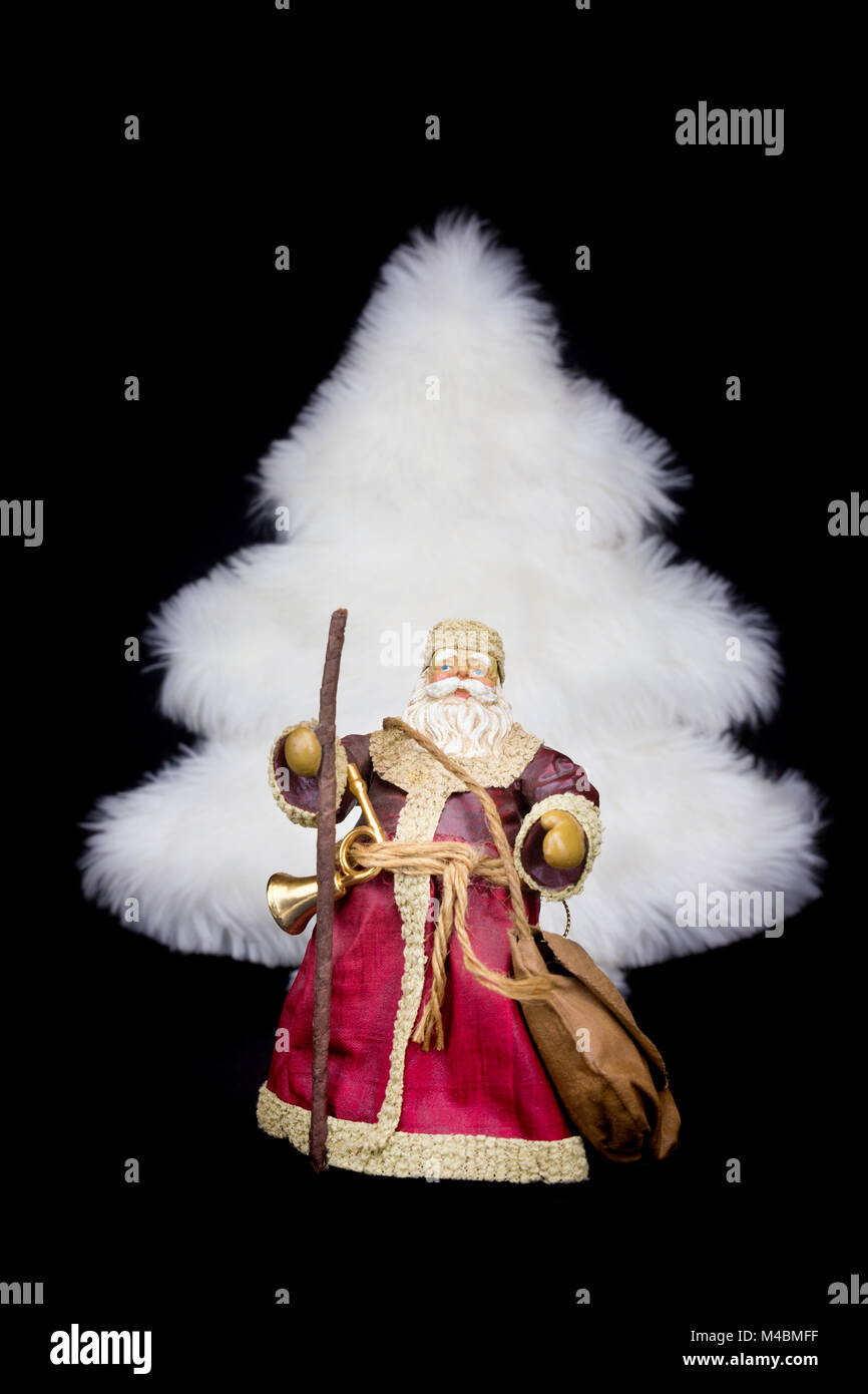 Santa Claus figurine white christmas tree on black background Stock Photo