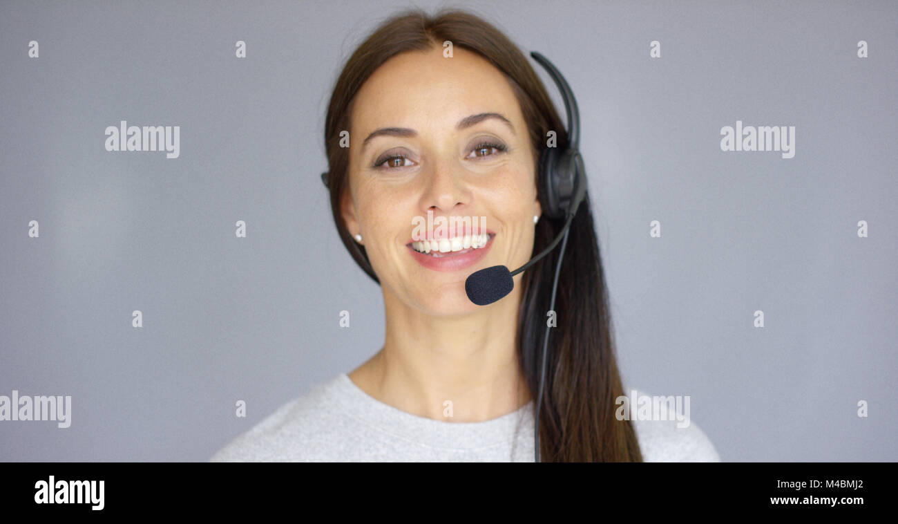 Adorable call center agent speaking with someone on headset Stock Photo