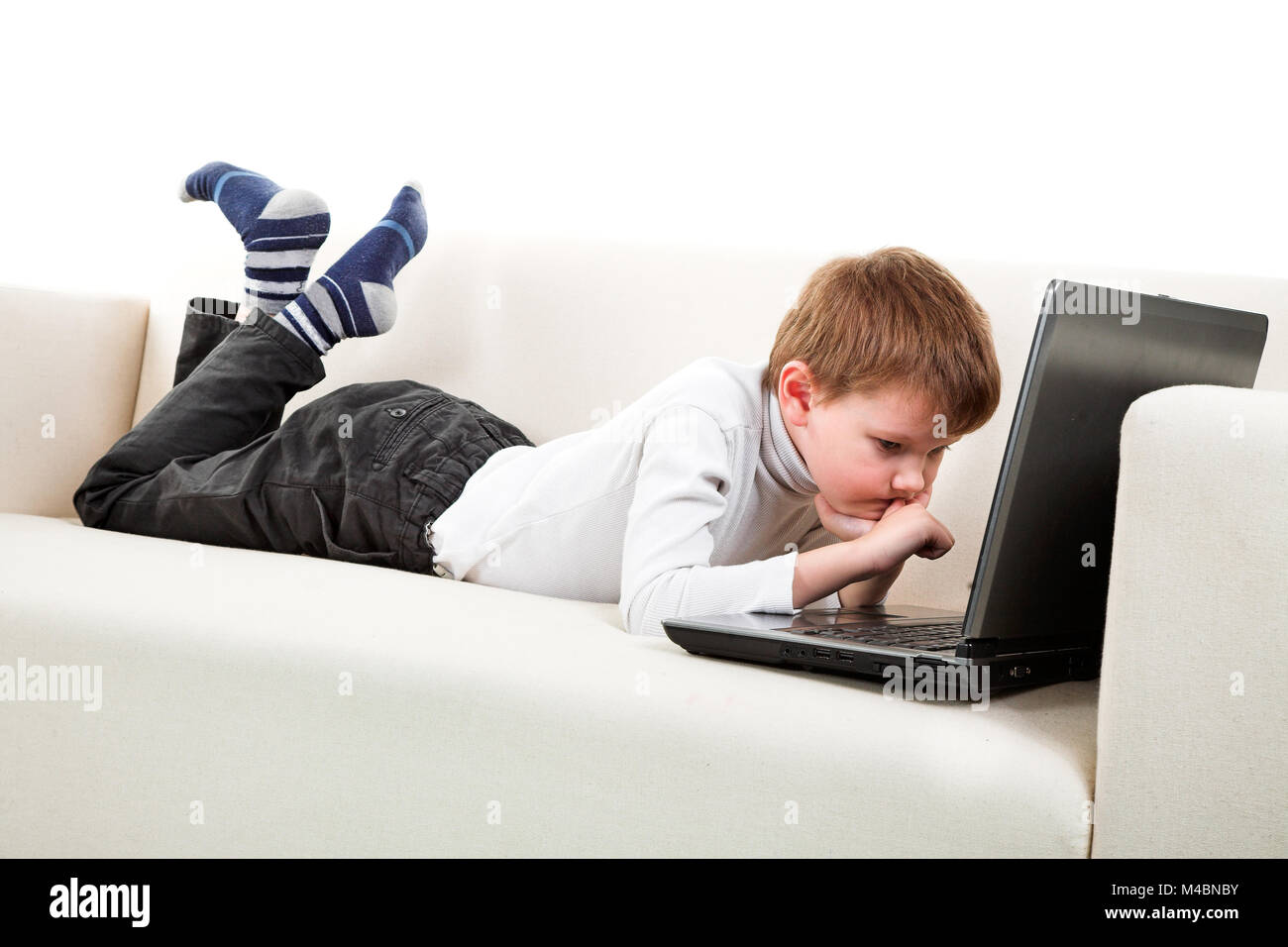 Two boys with laptop on the sofa Stock Photo - Alamy