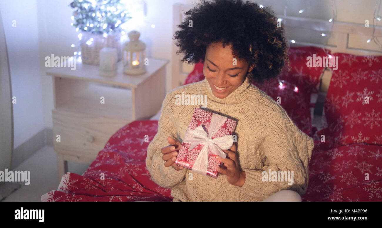 Smiling African woman holding Christmas gift Stock Photo - Alamy