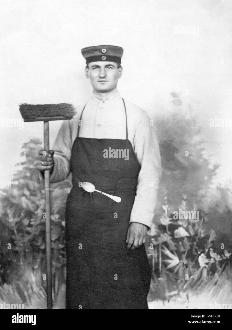 Soldier with broom and spoon,kitchen service,1910s,exact place unknown,Germany Stock Photo