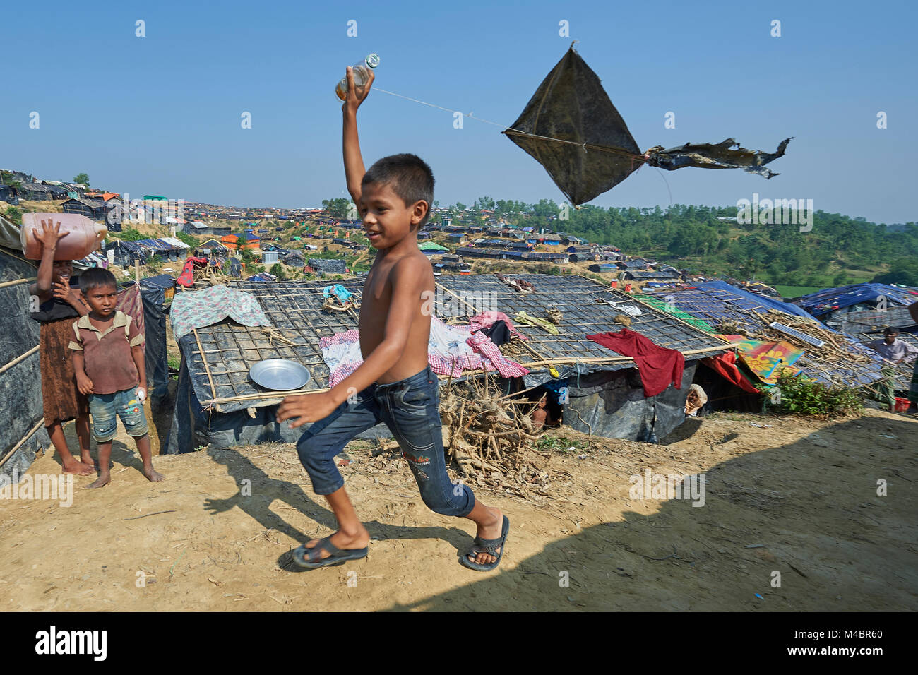 A Rohingya boy flies a kite in the Jamtoli Refugee Camp near Cox's Bazar, Bangladesh. Stock Photo