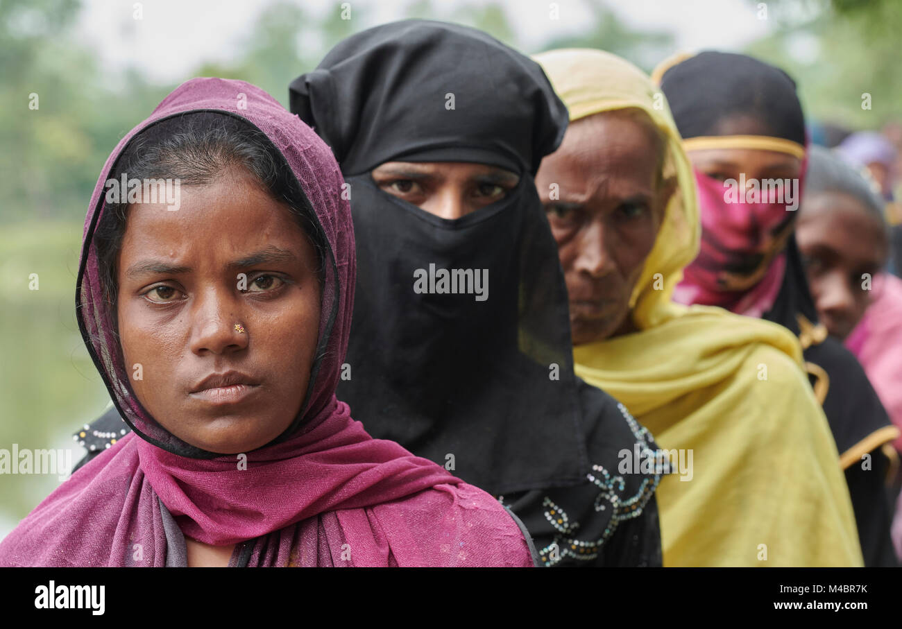 Rohingya refugee women line up to receive food in the Chakmarkul Refugee Camp near Cox's Bazar, Bangladesh. Stock Photo