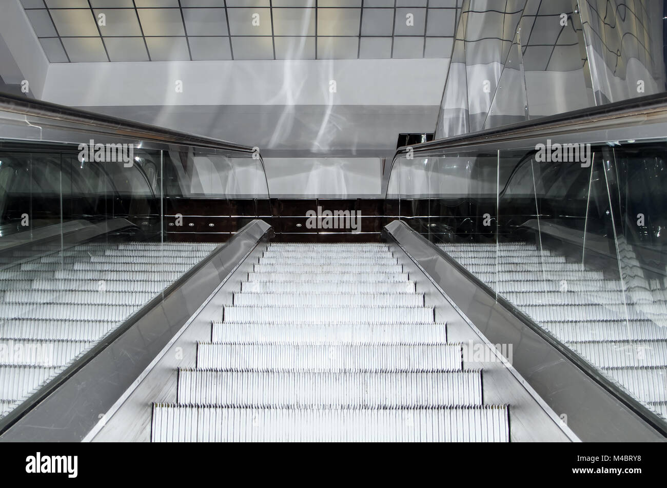 Empty escalator stairs moving up in modern office building Stock Photo