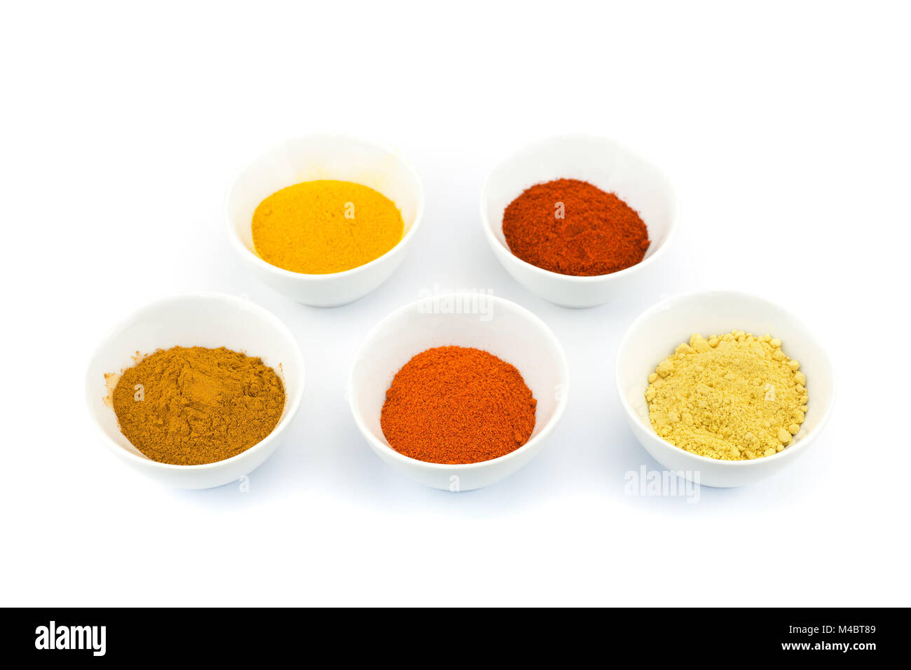 Porcelain bowls with several seasoning spices on white background Stock Photo