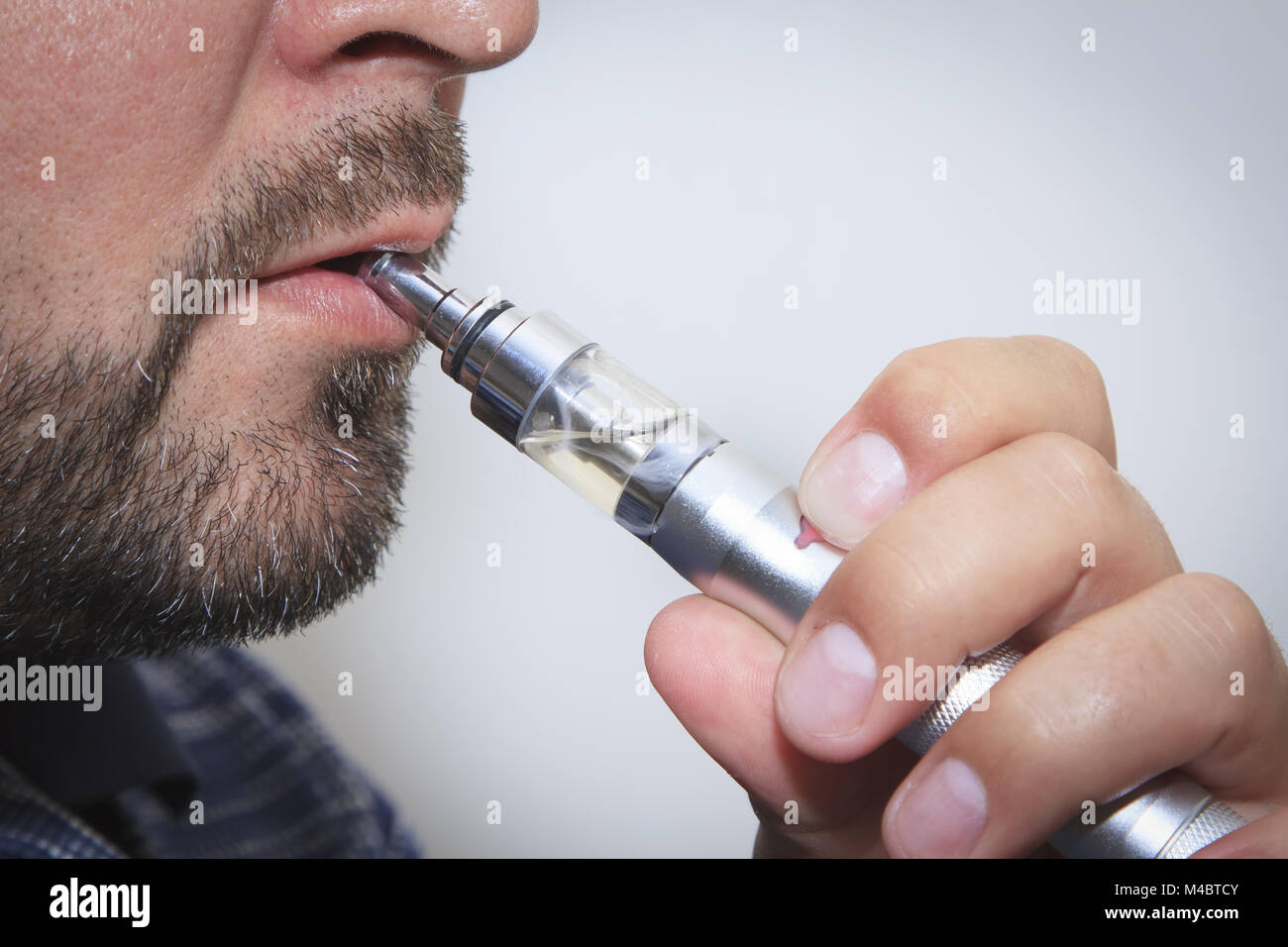 Profile view of man smoking electronic sigarette close up Stock Photo