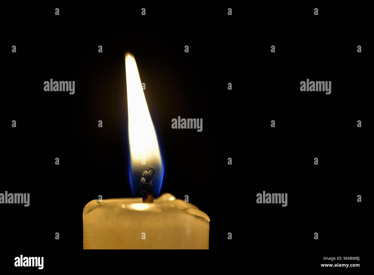 Burning wax candle on a black background Stock Photo Alamy