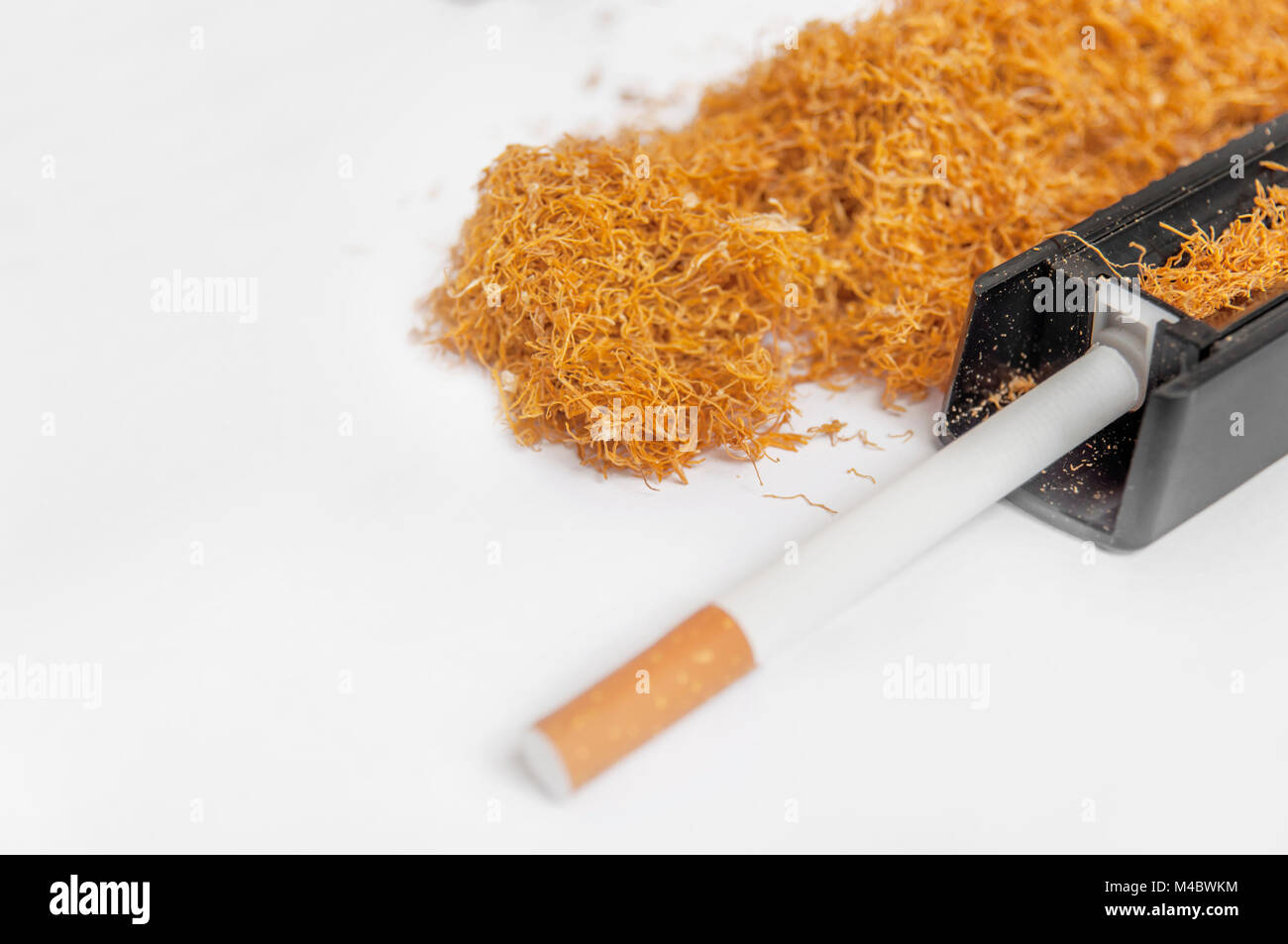 tobacco in one cigarette One cigarette rolling machine with addiction pile of tobacco on white Stock  Photo
