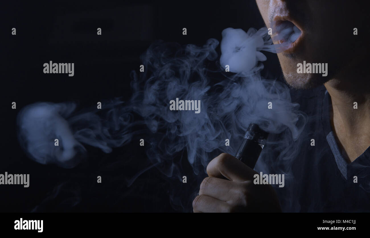 Man smoking electronic cigarette and Making Smoke Rings Stock Photo - Alamy